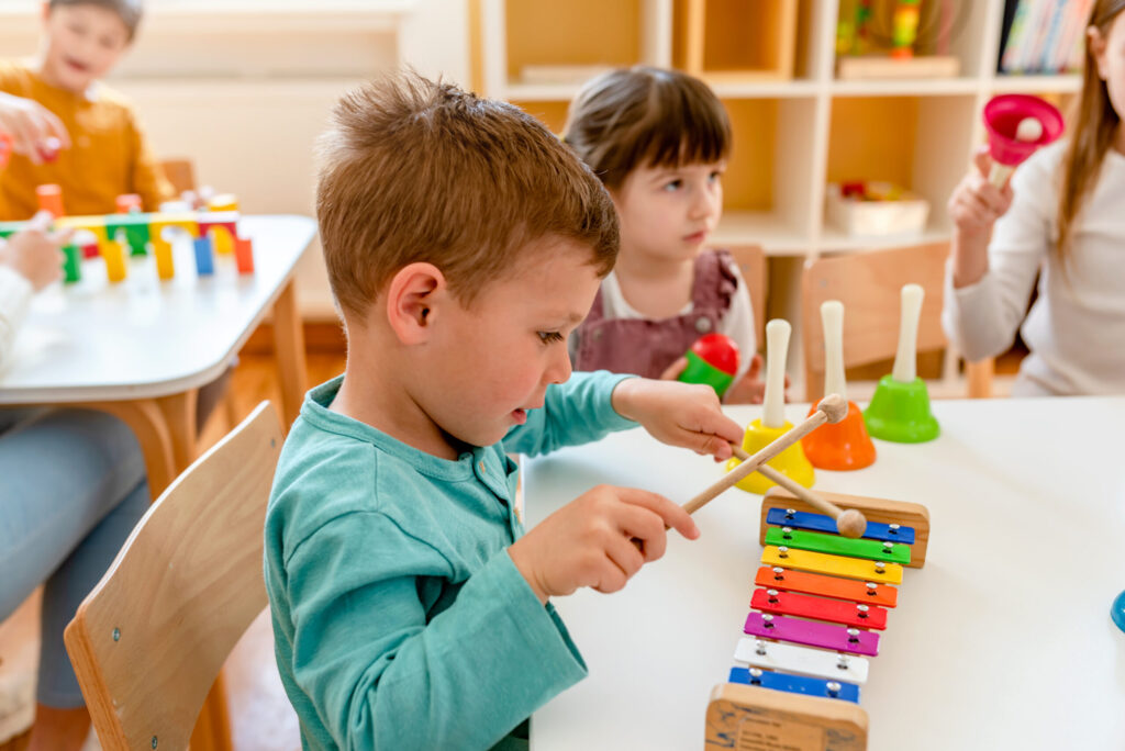 preschool children playing music using various colorful instruments